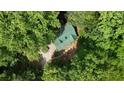 Aerial view of home with green metal roof and lush tree coverage in a private setting at 141 Mills Creek Path, Hiram, GA 30141