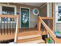 Inviting front porch with wood railing, steps, and a glass front door with unique windows at 141 Mills Creek Path, Hiram, GA 30141