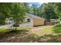 View of the backyard with the home, grass and a fenced-in area at 3345 Bomar Rd, Douglasville, GA 30135