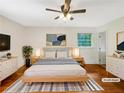 Staged bedroom with hardwood floors, a ceiling fan, and large windows at 2784 Williamsburg Way, Decatur, GA 30034