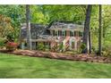 Beautiful brick home with manicured lawn, mature trees, and bay windows at 3402 Johnson Ferry Rd, Roswell, GA 30075