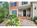 Close-up of a home with a front porch featuring chairs and lush plants at 2212 Mcquiston Sw Dr, Marietta, GA 30064