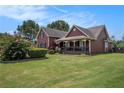 View of a charming two-story house with inviting front porch and beautifully landscaped yard at 1951 Chambers Rd, Mcdonough, GA 30253