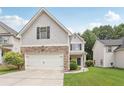 Charming home featuring a stone-accented facade, well-maintained lawn, and a convenient two-car garage at 4546 Water Mill Dr, Buford, GA 30519