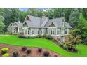 Beautiful home showing large lawn area, mature trees and impeccable landscaping at 114 Trinity Hollow Dr, Canton, GA 30115