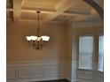 Elegant dining room featuring a coffered ceiling, decorative chandelier, and large bright windows at 1530 Horseshoe Creek Ln, Cumming, GA 30041