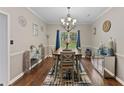 Elegant dining room with a stylish chandelier, wood floors, and modern decor at 76 Barrington Farms Pkwy, Sharpsburg, GA 30277