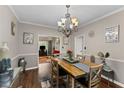 Open dining area featuring hardwood floors, a chandelier, and tastefully decorated walls at 76 Barrington Farms Pkwy, Sharpsburg, GA 30277