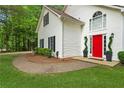 Charming white home featuring a bright red door, dark shutters, and manicured landscaping at 76 Barrington Farms Pkwy, Sharpsburg, GA 30277