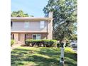 Two-story townhouse with brick facade, siding, and mature trees on a bright, sunny day at 1215 Willow Creek Nw Ct, Conyers, GA 30012