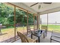 Relaxing screened-in patio with ceiling fan, outdoor seating, and view of backyard at 11581 Kades Trl, Hampton, GA 30228