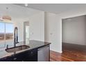 Kitchen sink area with dark cabinetry, granite countertop, stainless steel dishwasher, and hardwood floors at 3325 Piedmont Ne Rd # 2104, Atlanta, GA 30305