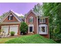 Charming brick home with a two-car garage, lush lawn, and mature trees at 6302 Manassas Nw Pass, Acworth, GA 30101