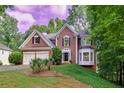 Beautiful brick home with a two-car garage and lush green lawn surrounded by mature trees at 6302 Manassas Nw Pass, Acworth, GA 30101
