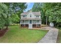 Inviting two-story home with a spacious front yard and a long driveway leading to a detached garage at 2060 Candlewood Ne Ct, Marietta, GA 30066