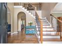 Welcoming foyer with hardwood floors, grand staircase, and elegant archways at 5396 Turnbill Nw Pt, Acworth, GA 30101