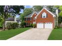 Traditional brick home with an attached two-car garage, mature trees and a well maintained lawn at 10865 Misty Moon Ct, Alpharetta, GA 30022