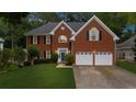 Charming two-story brick home with a well-manicured lawn and a two-car garage at 10865 Misty Moon Ct, Alpharetta, GA 30022