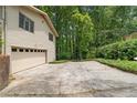 Attached garage and driveway with ample parking space, surrounded by mature trees at 217 Millbrook Farm Rd, Marietta, GA 30068