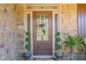 Elegant front door with decorative glass, surrounded by stone and potted greenery for added curb appeal at 2235 Well Springs Dr Dr, Buford, GA 30519