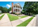 Traditional-style home featuring a chimney, double balconies, and a landscaped yard at 65 Orchard Dr, Covington, GA 30014
