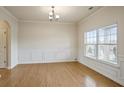 Bright dining room with hardwood floors, elegant wainscoting, and a large window offering ample natural light at 203 Creek View Ln, Acworth, GA 30102
