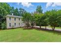 Charming two-story home featuring a well-manicured lawn, mature trees, and a welcoming entrance at 4773 Aberdeen Ln, Stone Mountain, GA 30083