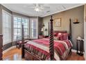 Bedroom featuring a four poster bed, ceiling fan, and large windows at 155 Matthew Way, Fayetteville, GA 30214