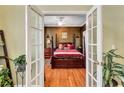 Cozy bedroom with hardwood floors, a ceiling fan and a four-poster bed at 155 Matthew Way, Fayetteville, GA 30214
