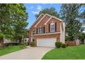 Attractive brick home showcases manicured lawn, mature trees, and a two-car garage at 3242 Monarch Pine Dr, Peachtree Corners, GA 30071