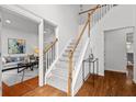 Bright foyer featuring hardwood floors, staircase with white railing, and views to the living and dining areas at 3242 Monarch Pine Dr, Peachtree Corners, GA 30071