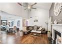Open-concept living area with hardwood floors, high ceilings, fireplace, and a view of the dining area at 4467 Pineridge Cir, Atlanta, GA 30338