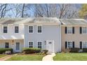 Attractive townhome showcasing a well manicured lawn and neat shrubbery leading to the front door at 834 Heritage Sq, Decatur, GA 30033
