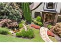 Beautifully landscaped front yard with a stone walkway, pond, and mature trees, enhancing the home's curb appeal at 3770 Riverly Trce, Marietta, GA 30067