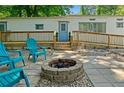 Inviting backyard features a paver patio, fire pit, Adirondack chairs, a ramp and a deck on a white home at 1000 Delta Dr, Canton, GA 30114