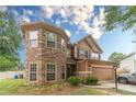 Beautiful two-story home with a stone accent turret and brown siding, complemented by lush greenery at 568 Musical Ct, Lawrenceville, GA 30044