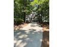 Long driveway approaching a beautiful home nestled among mature trees with great curb appeal at 2901 Briscoe Rd, Loganville, GA 30052