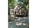 Charming two-story home with manicured landscaping, arched windows, black shutters, and a curved walkway at 2901 Briscoe Rd, Loganville, GA 30052