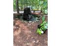 Beautiful water feature with mature trees, a stone surround, and flourishing green ground cover at 2901 Briscoe Rd, Loganville, GA 30052