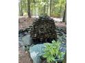 Picturesque outdoor space featuring a tiered stone water feature and lush greenery, creating a tranquil ambiance at 2901 Briscoe Rd, Loganville, GA 30052