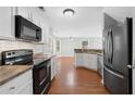Modern kitchen with white cabinets, stainless steel appliances, and wood floors at 174 Randall Dr, Rockmart, GA 30153