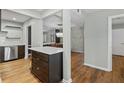Modern kitchen features wood floors, light paint and an island with a white countertop at 6851 Roswell Rd # H18, Atlanta, GA 30328