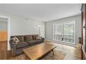 Living Room with wood floors, a large window, area rug, a couch, and a lamp at 6851 Roswell Rd # H18, Atlanta, GA 30328