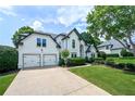 Beautiful home with a lush green lawn, mature trees, and a two-car garage at 3065 Foxhall Overlook, Roswell, GA 30075