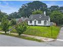 Charming home with dormer windows and a blue front door sits on a well-manicured lawn, surrounded by trees at 1283 Beecher Sw St, Atlanta, GA 30310
