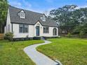 Charming home showcasing a blue front door, dormer windows, gray roof, and a curved sidewalk at 1283 Beecher Sw St, Atlanta, GA 30310