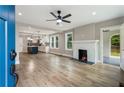 Open-concept living room with a fireplace, ceiling fan, hardwood floors, and an archway to another room at 1283 Beecher Sw St, Atlanta, GA 30310