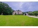 Beautifully landscaped home with a lush green lawn and mature trees at 157 Hambrick Dr, Stockbridge, GA 30281