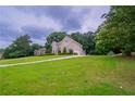Beautifully landscaped home with a lush green lawn and mature trees at 157 Hambrick Dr, Stockbridge, GA 30281