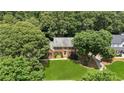 Beautiful home nestled among mature trees, showcasing its well-maintained lawn and classic architecture at 3267 Remembrance Trce, Lawrenceville, GA 30044